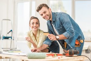 happy young couple with credit card smiling at camera during home improvement